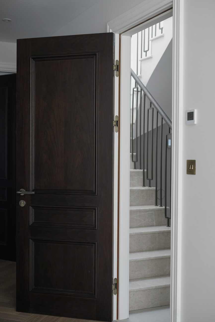 Brass-hinged panelled door by staircase